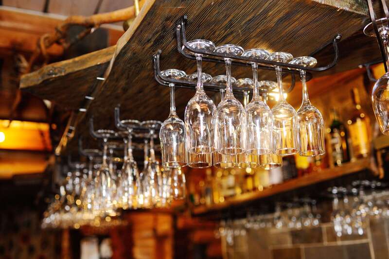 Champagne glasses hanging on a rack in a bar