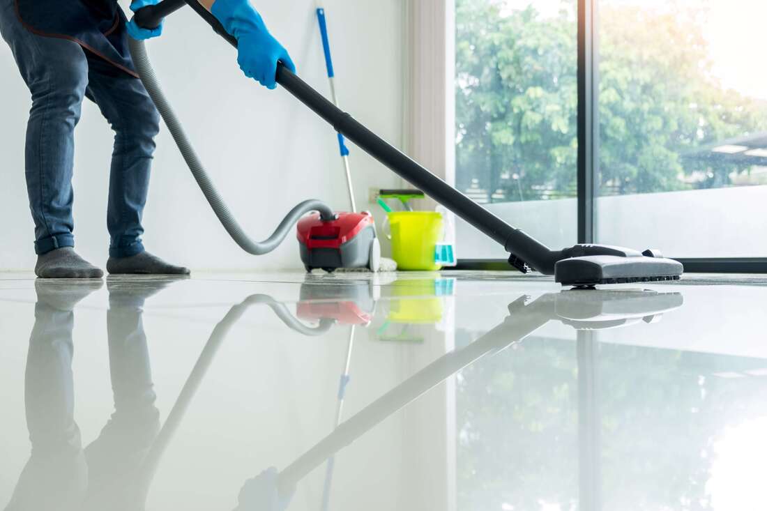 Professional cleaner using a vacuum to clean the floor