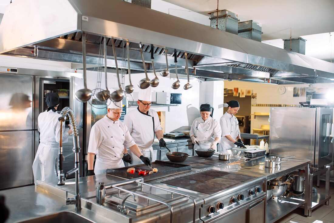 restaurant kitchen with line cooks preparing food